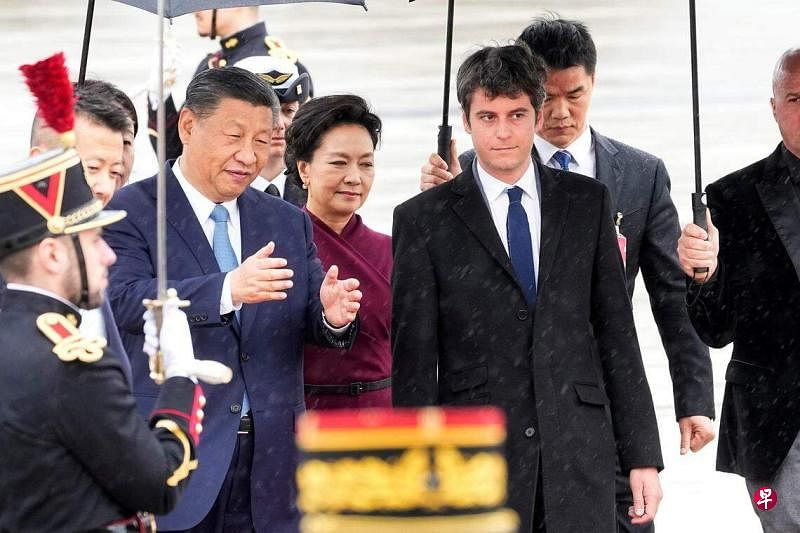 法國總理阿塔爾（前排右）星期天到巴黎奧利國際機場迎接中國國家主席習近平和夫人彭麗媛到訪。（路透社）