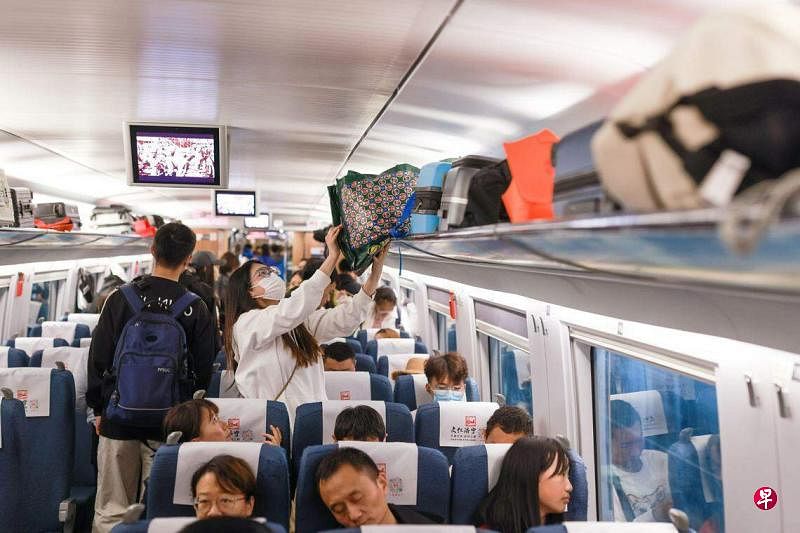 图为中国“五一”假期首日，旅客在北京南站乘坐高铁列车。（ 中新社）