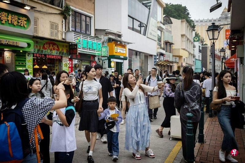 香港和澳门一向是中国大陆居民出境游的热门目的地。图为今年5月2日澳门大街上的大陆游客群。（彭博社）