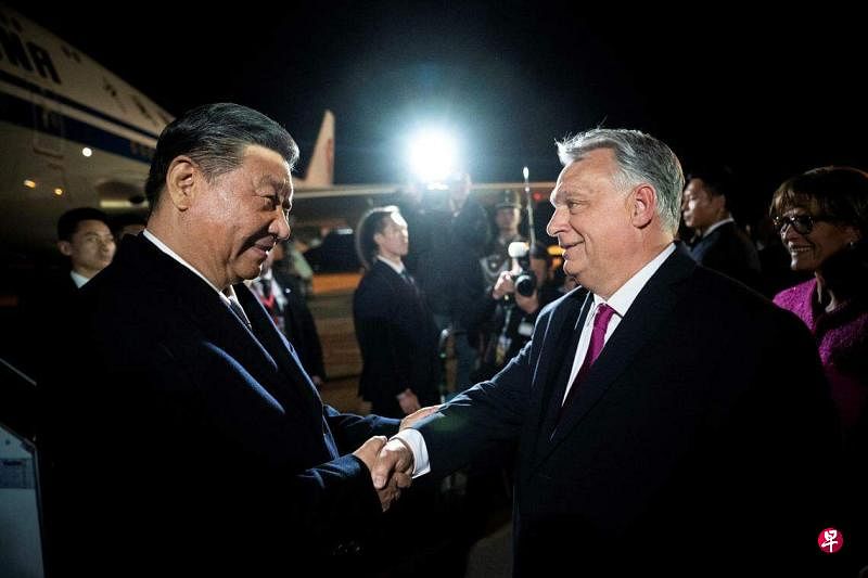 中国国家主席习近平（左）星期三晚抵达布达佩斯国际机场时，匈牙利总理欧尔班到场接机，两人握手致意。（路透社）
