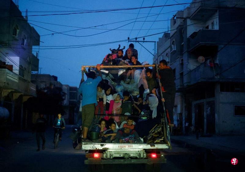 在以军不断逼近之际，拉法的巴勒斯坦平民纷纷举家逃难。5月9日，一批巴勒斯坦平民挤在一辆破旧的小车上，在夜色中离开拉法。（路透社）