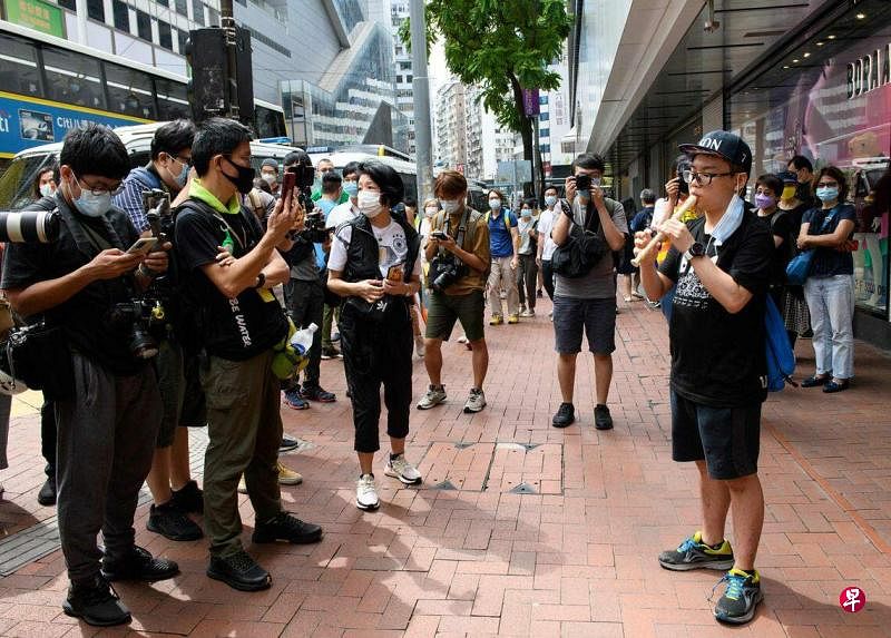 一名男子于2020年10月1日即中国国庆期间在香港街道上用长笛演奏《愿荣光归香港》。（法新社档案照）