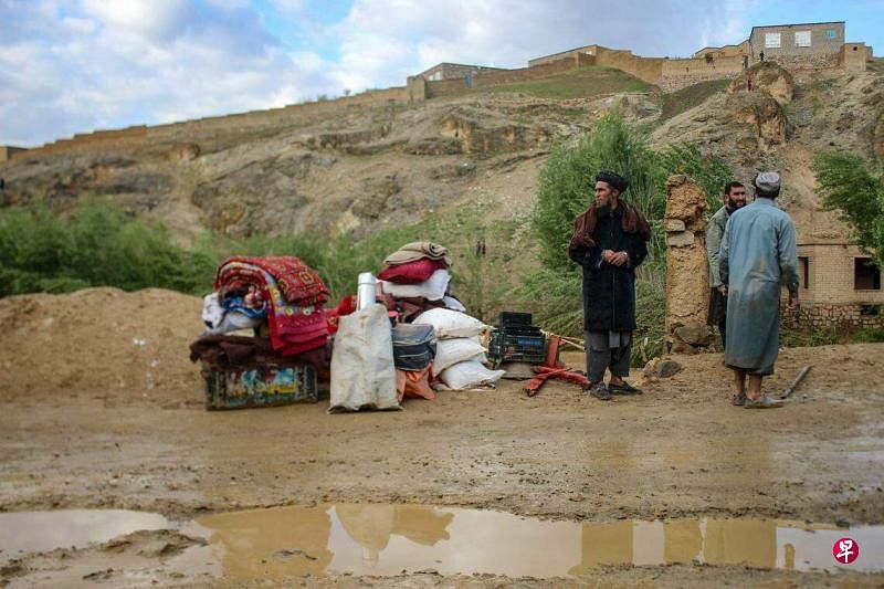 阿富汗西部古尔省因暴雨引发洪灾，造成至少50人死亡。图为受影响的灾民带着他们的随身物品避难。（法新社）