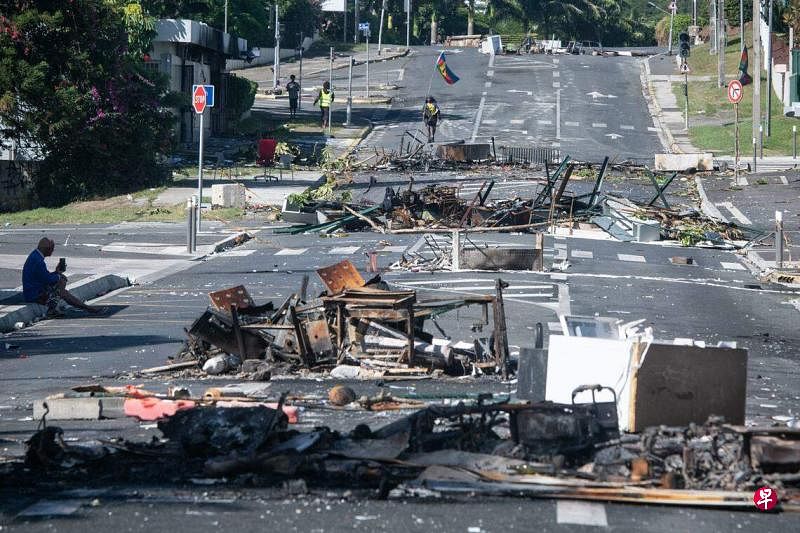 5月18日，在新喀里多尼亚首都努美阿，一条街道在骚乱后被烧毁的物品堵住。（法新社）