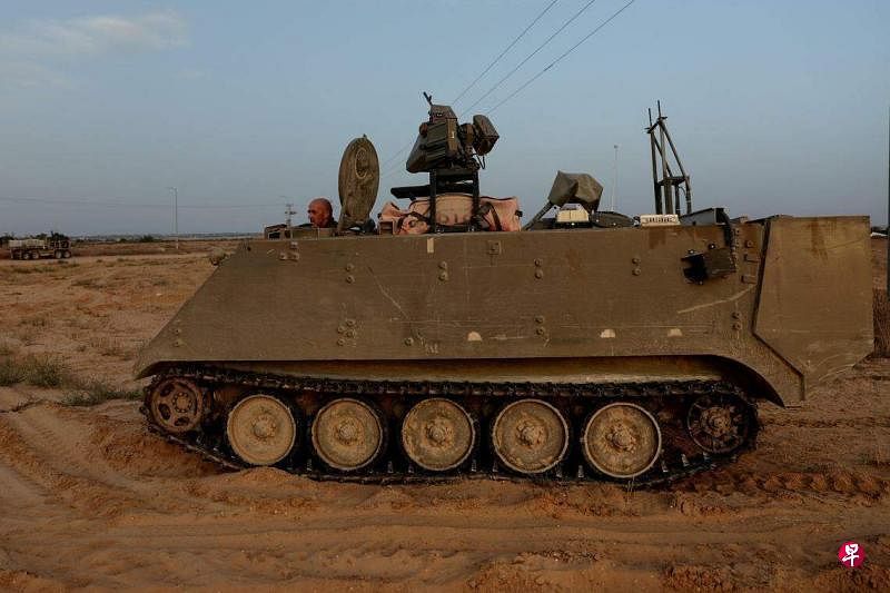 5月17日，在以色列与拉法交界的凯雷姆沙洛姆过境点外，一名以军士兵正在驾驶一辆装甲运兵车。（路透社）