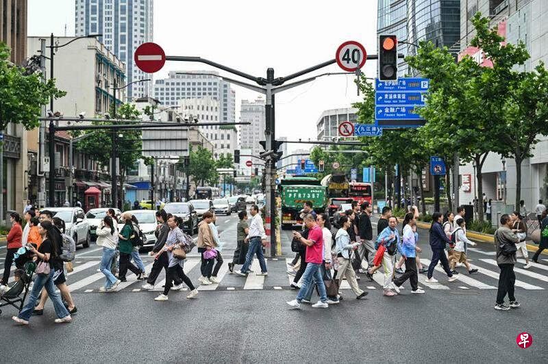 人们在上海黄浦区过马路，图片拍摄于今年6月6日。（法新社）