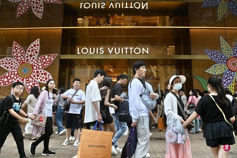 香港旅游和零售业在疫后虽见复苏，但速度比预期中低，图为香港名牌店外的行人。（中新社）