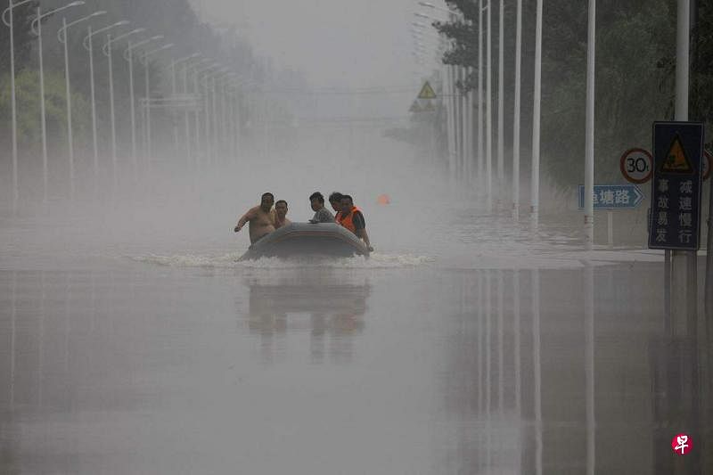 去年8月，河北涿州发生严重汛情，图为救援人员和河北涿州民众8月3日乘坐救援船穿过被淹没的道路。（路透社资料图片）