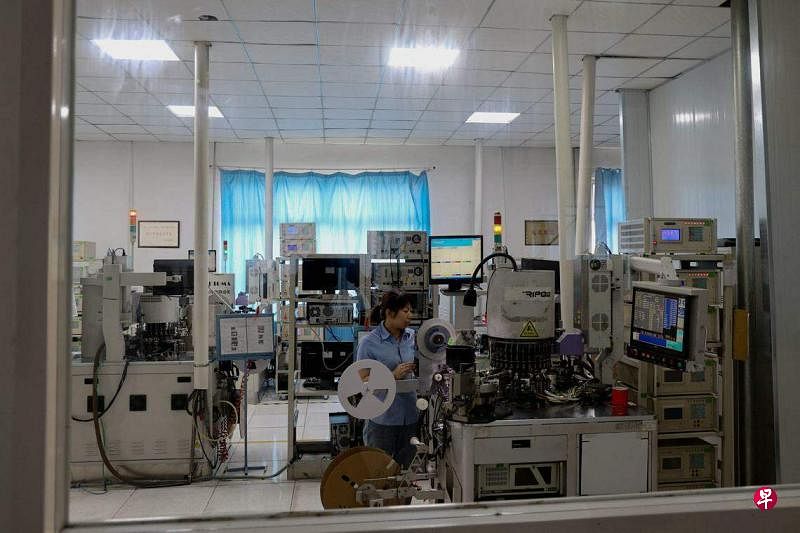 中国山东省滨州市一名员工在一家半导体芯片工厂工作。（法新社）