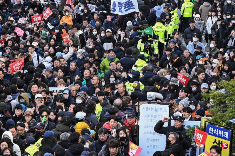 12月7日,大量民众聚集在首尔国会议事堂外举行抗议。(法新社)