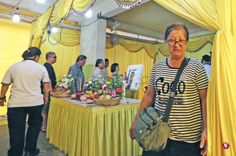 伤心的黄女士负伤送夫一程。(洪璐华摄) 伤心的黄女士负伤送夫一程。(洪璐华摄)