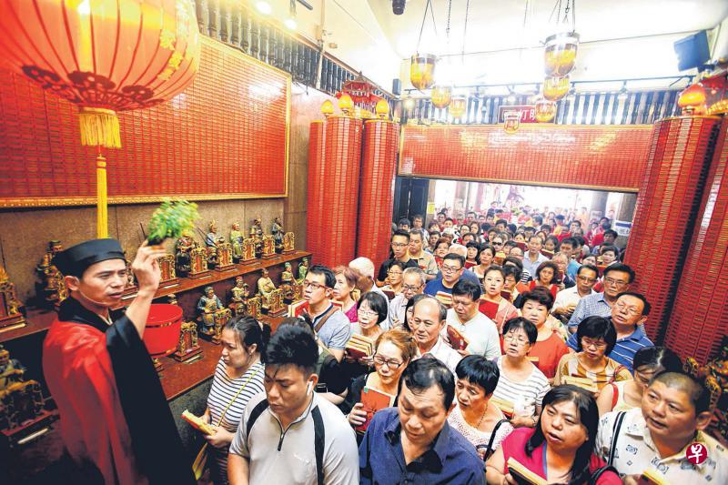 韭菜芭城隍庙的黄信成道长(左)在太岁殿为拜太岁的信众诵念祷文和祈福。(蔡婉婷摄) 韭菜芭城隍庙的黄信成道长(左)在太岁殿为拜太岁的信众诵念祷文和祈福。(蔡婉婷摄)