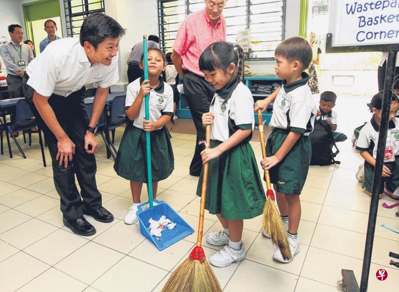 教育部代部长（学校）黄志明（左一）昨天走访醒南小学，观察小学生如何保持课室清洁。（陈福洲摄）