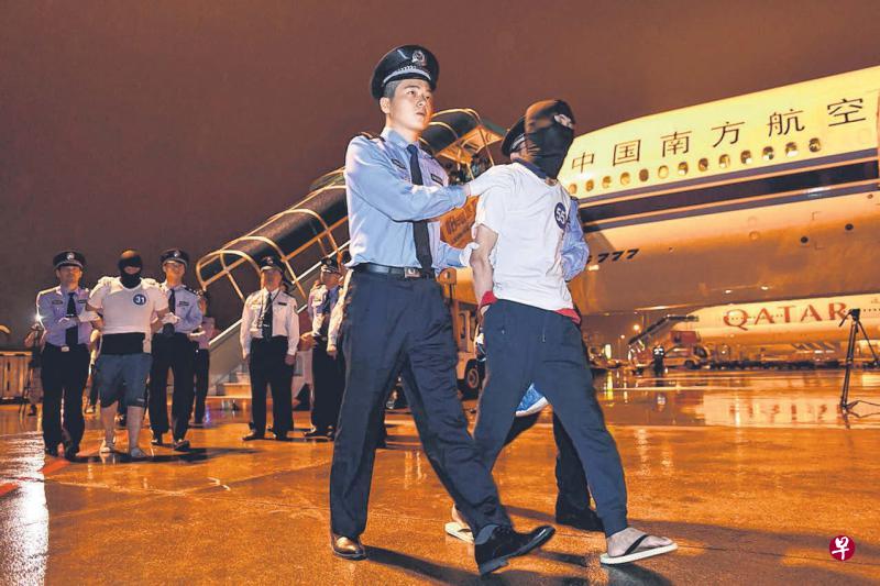 97名电信诈骗犯罪嫌疑人,昨晚从马来西亚乘包机到广州白云国际机场后,由公安民警押解走下飞机。(新华社) 97名电信诈骗犯罪嫌疑人,昨晚从马来西亚乘包机到广州白云国际机场后,由公安民警押解走下飞机。(新华社)