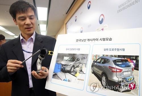韩国环境部负责人介绍逍客零部件。(韩联社) 韩国环境部负责人介绍逍客零部件。(韩联社)