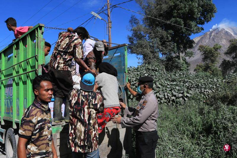 印尼锡纳朋火山周六喷发出炽热的火山灰后,拯救人员昨日协助村民紧急疏散。(法新社) 印尼锡纳朋火山周六喷发出炽热的火山灰后,拯救人员昨日协助村民紧急疏散。(法新社)