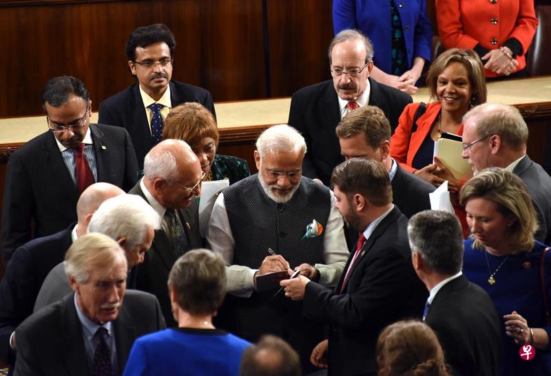莫迪(中)演讲后,美国国会议员向他索要签名。(中新社) 莫迪(中)演讲后,美国国会议员向他索要签名。(中新社)