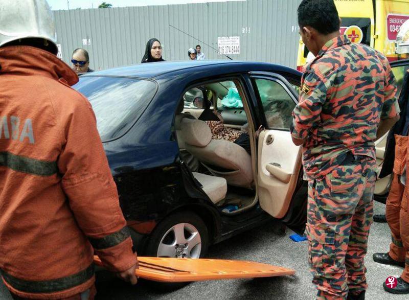 马来西亚消拯人员准备将女司机的遗体从车内移走。(星洲日报) 马来西亚消拯人员准备将女司机的遗体从车内移走。(星洲日报)