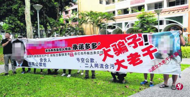 投资者们印制布条,在警察广东民大厦附近组屋抗议。(洪璐华/摄) 投资者们印制布条,在警察广东民大厦附近组屋抗议。(洪璐华/摄)