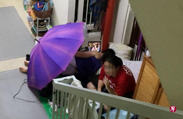 母女被邻居投诉后,开伞“遮丑”继续睡在走廊。(受访者提供) 母女被邻居投诉后,开伞“遮丑”继续睡在走廊。(受访者提供)