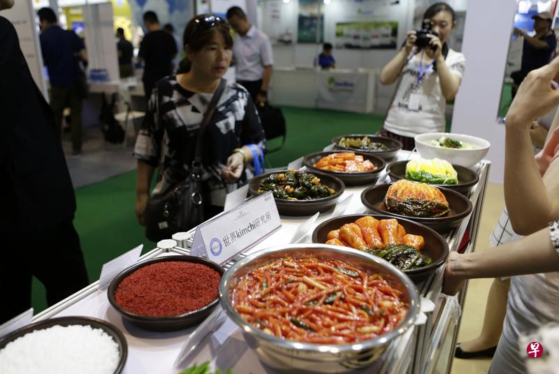 6月20日,在北京举行的2016中国国际食品安全与创新技术展览会韩国特色泡菜展区吸引参观者。(中新社) 6月20日,在北京举行的2016中国国际食品安全与创新技术展览会韩国特色泡菜展区吸引参观者。(中新社)