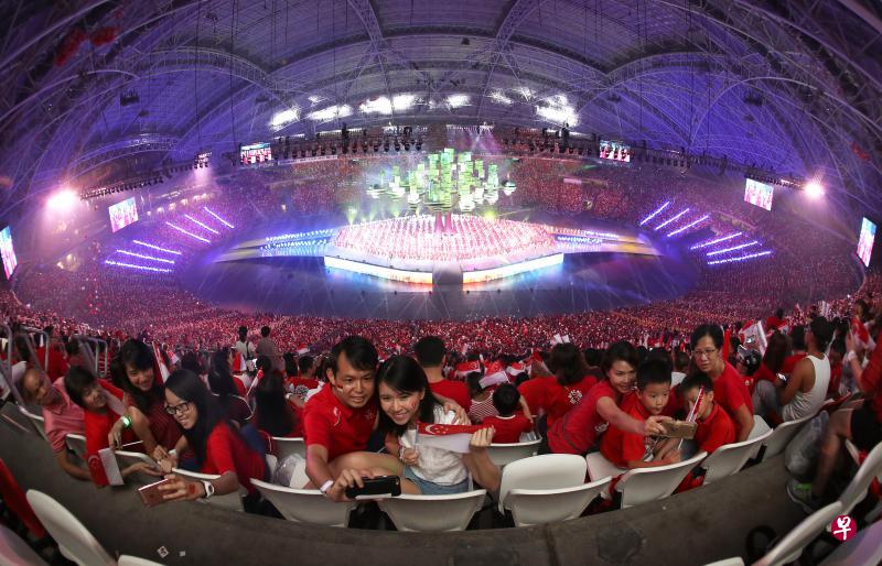 国家体育场再次举行国庆庆典,5万5000多人重现加冷许久未见的红海。沈蓉合和男友张田平(中间两人),以及坐在两人身旁的一家人都通过手机自拍,留下难得的国庆回忆。(何炳耀摄) 国家体育场再次举行国庆庆典,5万5000多人重现加冷许久未见的红海。沈蓉合和男友张田平(中间两人),以及坐在两人身旁的一家人都通过手机自拍,留下难得的国庆回忆。(何炳耀摄)