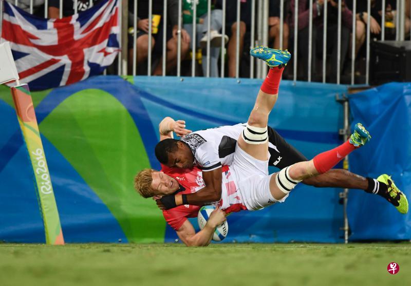 英国球员罗伯森(下)持球时,遭到斐济球员图尔索瓦的拦截。(法新社) 英国球员罗伯森(下)持球时,遭到斐济球员图尔索瓦的拦截。(法新社)