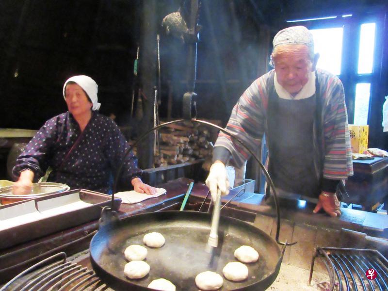 　长野县小川村煎饼厂最高龄员工、92岁的权田进芳手脚利落，一天不干活，全身不自在。他身旁86岁的老婆婆，日均站立煎烧饼八小时，一点也不觉得累。（符祝慧摄）
