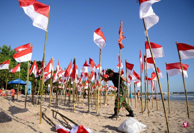 印尼今天庆祝独立日,昨天在度假胜地峇厘岛海边有一个预先庆祝活动,军人配合活动在沙滩上布了个国旗阵。(法新社) 印尼今天庆祝独立日,昨天在度假胜地峇厘岛海边有一个预先庆祝活动,军人配合活动在沙滩上布了个国旗阵。(法新社)