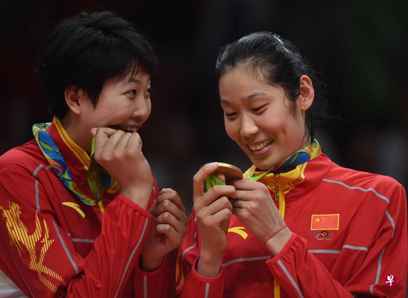 中国女排队员袁心玥(左)和朱婷在颁奖仪式上观看金牌。(新华社) 中国女排队员袁心玥(左)和朱婷在颁奖仪式上观看金牌。(新华社)