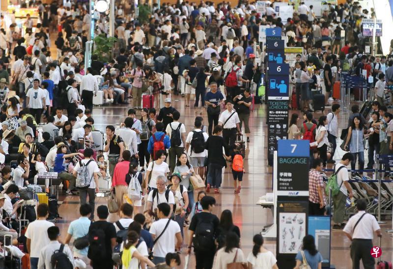 风雨拦阻航班,东京羽田机场的离境大厅里昨天挤满了受困的乘客。(法新社) 风雨拦阻航班,东京羽田机场的离境大厅里昨天挤满了受困的乘客。(法新社)