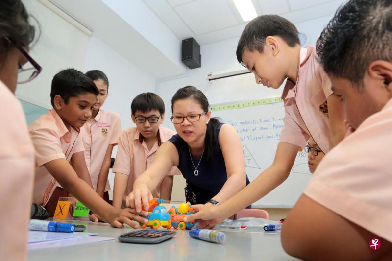 胡月美(中)用玩具车帮助学生理解距离和时速的概念,希望通过有趣的学习活动使数学成为“活学活用”的科目。 (严宣融摄) 胡月美(中)用玩具车帮助学生理解距离和时速的概念,希望通过有趣的学习活动使数学成为“活学活用”的科目。 (严宣融摄)