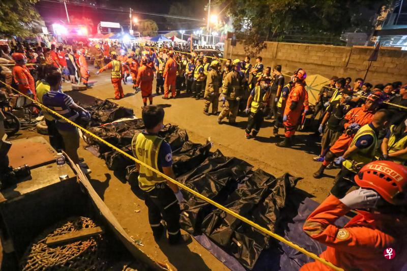 达沃夜市发生爆炸，救援队通宵达旦工作，收拾遇难者的遗体和清理现场。（法新社）