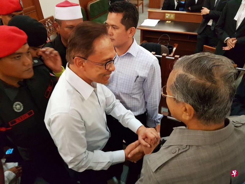 马哈迪(右)突然现身高庭,与安华会面,两人时隔18年第一次握手寒暄的照片出现在人民公正党面簿上。(星洲日报) 马哈迪(右)突然现身高庭,与安华会面,两人时隔18年第一次握手寒暄的照片出现在人民公正党面簿上。(星洲日报)