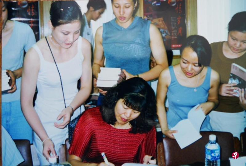 ←1999初秋,郎平(中,穿红衣者)为读者在其新书上签名。 ←1999初秋,郎平(中,穿红衣者)为读者在其新书上签名。