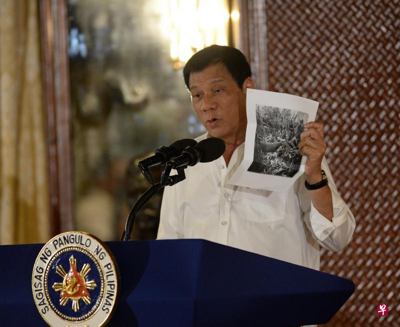 杜特尔特周一在新任政府官员宣誓就职典礼上致辞时,指菲南穆斯林叛乱多年来一直无法平定,追根究底是美军的错。他还出示一张照片,举例说明美国在1900年代初占领菲律宾时,美军曾屠杀穆斯林。(法新社) 杜特尔特周一在新任政府官员宣誓就职典礼上致辞时,指菲南穆斯林叛乱多年来一直无法平定,追根究底是美军的错。他还出示一张照片,举例说明美国在1900年代初占领菲律宾时,美军曾屠杀穆斯林。(法新社)