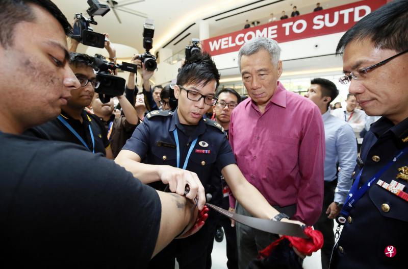 昨天在全国保家安民计划推介会上,新加坡民防部队人员为李显龙总理(右二)示范如何为“伤者”止血。(梁麒麟摄) 昨天在全国保家安民计划推介会上,新加坡民防部队人员为李显龙总理(右二)示范如何为“伤者”止血。(梁麒麟摄)