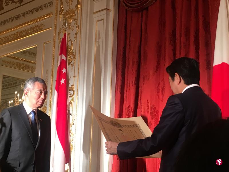 日本首相安倍晋三代表日本政府向李光耀授予勋章,由李显龙总理代领。(何惜薇摄) 日本首相安倍晋三代表日本政府向李光耀授予勋章,由李显龙总理代领。(何惜薇摄)