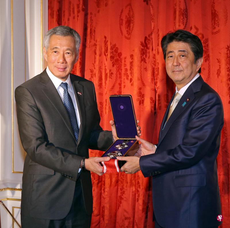 日本首相安倍晋三(右)把追授给新加坡建国总理李光耀的一等桐花大绶章交给李显龙总理。安倍在嘉奖词中形容李光耀是“亚洲为现代世界带来的最伟大智者之一”。(海峡时报) 日本首相安倍晋三(右)把追授给新加坡建国总理李光耀的一等桐花大绶章交给李显龙总理。安倍在嘉奖词中形容李光耀是“亚洲为现代世界带来的最伟大智者之一”。(海峡时报)