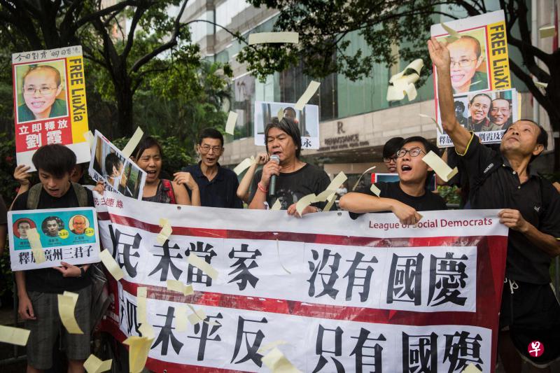 外号“长毛”的香港立法会议员梁国雄(右三)昨天和支持者在举行国庆酒会的会展中心外示威,要求北京当局释放国内政治犯。(法新社) 外号“长毛”的香港立法会议员梁国雄(右三)昨天和支持者在举行国庆酒会的会展中心外示威,要求北京当局释放国内政治犯。(法新社)