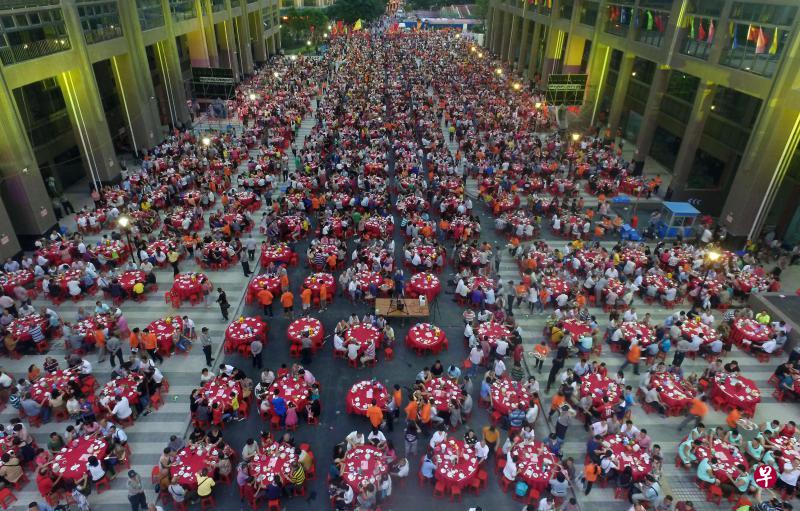 广州杨箕村村民前晚举办万人宴，在新建楼房空地席开1500桌，庆祝拆迁改造工程完工并顺利回迁新居，场面盛大。（路透社）