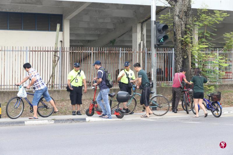 陆交局活跃通勤执法小组昨早在达曼裕廊一带展开巡逻行动,提醒脚踏车骑士和个人代步工具使用者在过马路或人多地点应下车推行,以确保自身与他人安全。(邝启聪摄) 陆交局活跃通勤执法小组昨早在达曼裕廊一带展开巡逻行动,提醒脚踏车骑士和个人代步工具使用者在过马路或人多地点应下车推行,以确保自身与他人安全。(邝启聪摄)