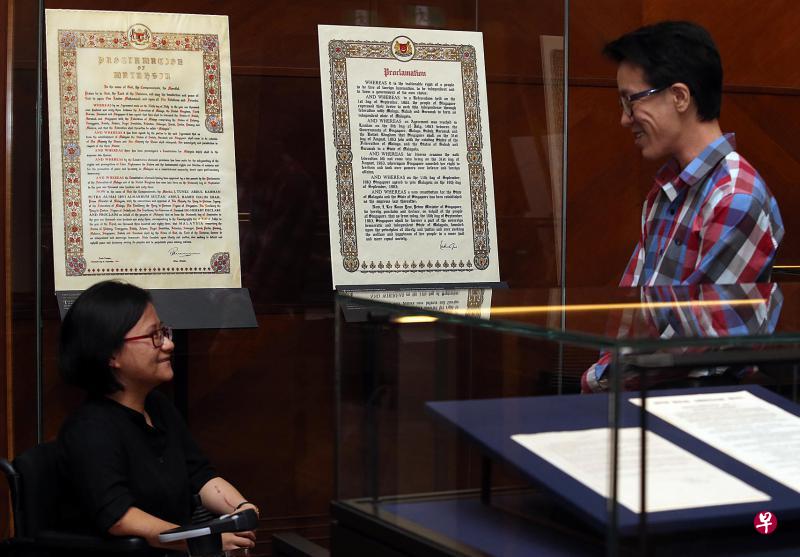 国家档案馆的口述历史研究员王文伟(右)和副档案馆员陈禄彬用一年策划《国土之法》展览。这两份历史文献是新马合并时的宣言。(邬福梁摄) 国家档案馆的口述历史研究员王文伟(右)和副档案馆员陈禄彬用一年策划《国土之法》展览。这两份历史文献是新马合并时的宣言。(邬福梁摄)