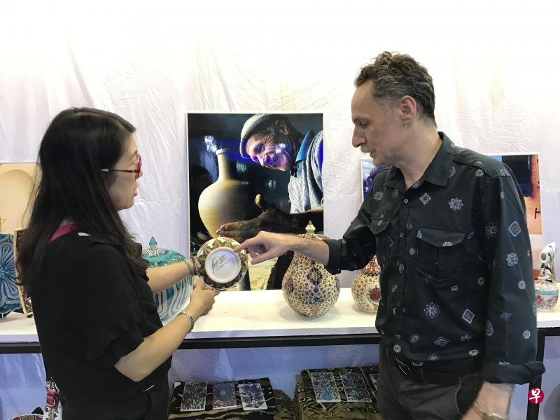 土耳其陶器商人Gokhan Bukmus向客人介绍产品细节。 土耳其陶器商人Gokhan Bukmus向客人介绍产品细节。