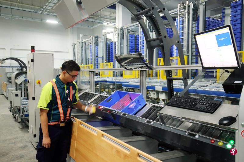 新邮政物流中心内的仓库采用按灯取货系统,帮助员工提升工作效率并降低失误率。(谢智扬摄) 新邮政物流中心内的仓库采用按灯取货系统,帮助员工提升工作效率并降低失误率。(谢智扬摄)