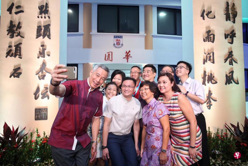李显龙总理(前排左一)昨晚出席华义中学60周年校庆晚宴,与贸工部兼文化、社区及青年部高级政务部长沈颖(后排左二)、华义中学校长郑淑华(前排右二)以及师生校友在校舍前自拍。(叶振忠摄) 李显龙总理(前排左一)昨晚出席华义中学60周年校庆晚宴,与贸工部兼文化、社区及青年部高级政务部长沈颖(后排左二)、华义中学校长郑淑华(前排右二)以及师生校友在校舍前自拍。(叶振忠摄)