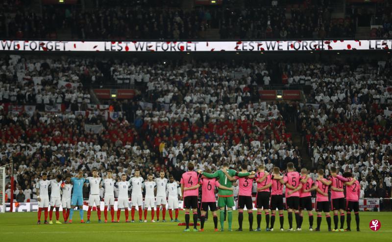 英格兰和苏格兰球员,以及全场观众起立静默一分钟,悼念在一战中牺牲的英国烈士。(路透社) 英格兰和苏格兰球员,以及全场观众起立静默一分钟,悼念在一战中牺牲的英国烈士。(路透社)