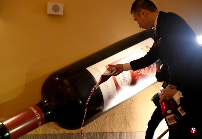 箱根小涌园侍酒师将法国薄酒萊新酒倒入池里,让游客沐浴。(法新社) 箱根小涌园侍酒师将法国薄酒萊新酒倒入池里,让游客沐浴。(法新社)