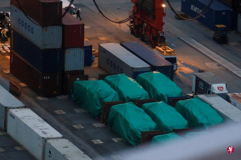 被香港海关扣留在葵涌货柜码头的九辆新加坡武装部队装甲车，被灰色与蓝色的篷布覆盖，并以大量集装箱包围，防止其他人靠近。（路透社）
