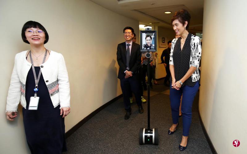 总理公署高级政务部长杨莉明(右一)昨天通过远程机器人和正在放产假的3E公司职员交谈。左起分别是3E公司创办人蔡淑霞和蔡忠洪。 总理公署高级政务部长杨莉明(右一)昨天通过远程机器人和正在放产假的3E公司职员交谈。左起分别是3E公司创办人蔡淑霞和蔡忠洪。